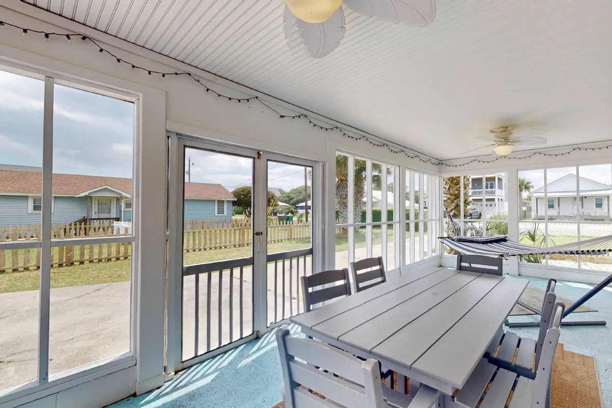A spacious, casual dining area with a large table and a cozy hammock near big windows, filled with natural light. The setting is ideal for family meals, group gatherings, or relaxing mornings together. The layout is open and welcoming, mirroring the flexibility and communal atmosphere described in the section.